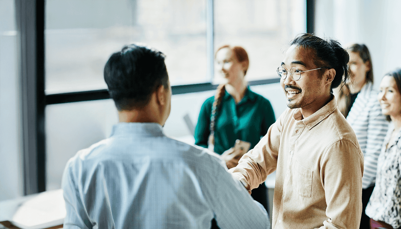 一组同事在一位现代办事处彼此独立,在专业引入期间戴上手动微笑。